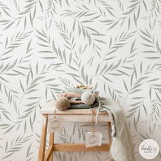 a table with a stuffed animal on top of it next to a wallpapered background