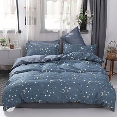 the comforter is made up with stars and moon designs on it, while the curtains are open