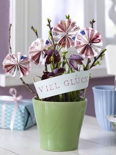 a vase filled with flowers sitting on top of a table next to cups and saucers