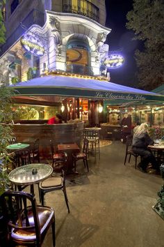 an outdoor restaurant with tables and chairs at night