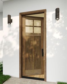 the front door to a house with grass on the ground and light fixture above it