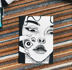 a drawing of a woman's face on top of a piece of paper next to markers