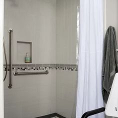 a bathroom with a shower, sink and towel rack