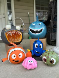 some toys that are sitting on the ground in front of a house with pumpkins