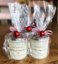 two small jars filled with candy canes on top of a wooden table