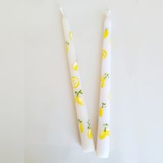 two white candles with lemons on them