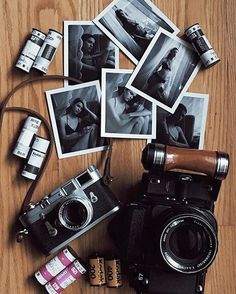 an old camera and several polaroid pictures on a wooden table with other items around it