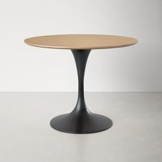 an oval wooden table sitting on top of a white floor