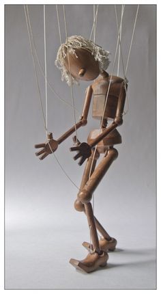 a wooden figure is swinging on strings with his hands and feet in the shape of a human