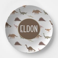 a plate with dinosaurs on it that says eldon in the center and brown lettering