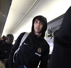 a man wearing a black hoodie on an airplane