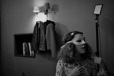 a woman wearing a blindfold standing in front of a mirror with a light on her head