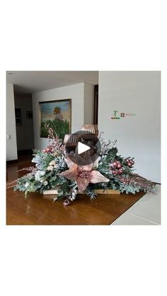 an arrangement of flowers and greenery is displayed in the middle of a living room