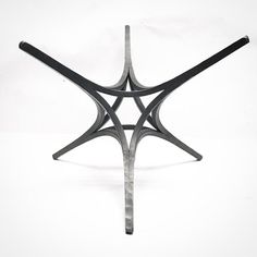 a black and white photo of a metal object with four intersecting sections on each side