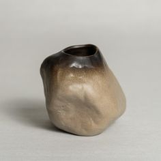 a brown vase sitting on top of a white table