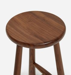 the wooden stool is made from wood and has two legs that are bent to one side