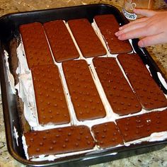 there is a tray of ice cream and cookies on the counter with someone's hand