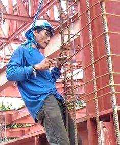 a man climbing up the side of a building with ropes on his hands and feet