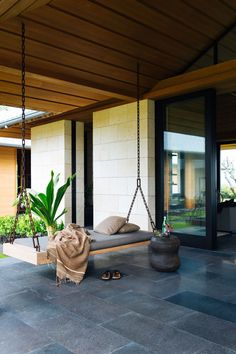 a porch with a swing and pillows on it