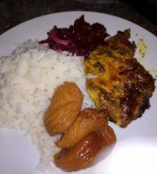 a white plate topped with meat and rice