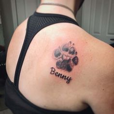 a woman with a dog paw tattoo on her upper arm and the word penny written in black ink