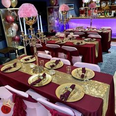 the tables are set with gold plates and red tablecloths for a party or celebration