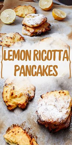 lemon ricotta pancakes on a baking sheet with powdered sugar and sliced lemons