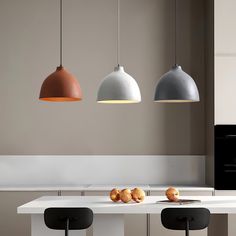 three pendant lights hanging over a kitchen island