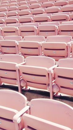 rows of pink seats in an empty stadium