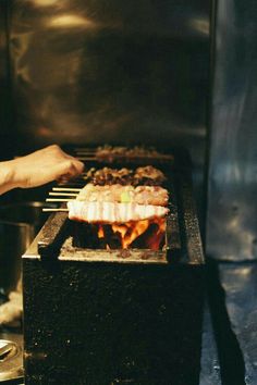 a person is cooking food on a grill