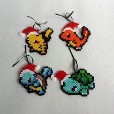 four pixelated christmas ornament ornaments on a white surface with black string and red santa's hat hanging from the top