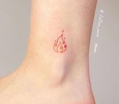 a small tattoo on the ankle of a woman's foot with a fire symbol