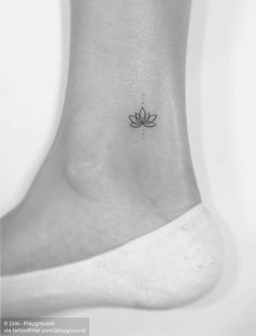 a small lotus tattoo on the ankle