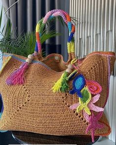 a crocheted handbag sitting on top of a table next to a potted plant