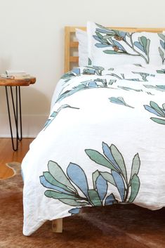 a bed with blue and green leaves on it