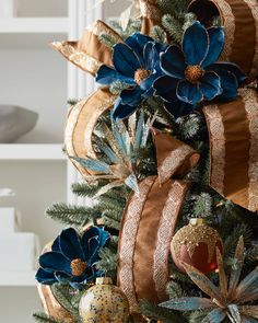 a christmas tree decorated with blue and gold ribbons