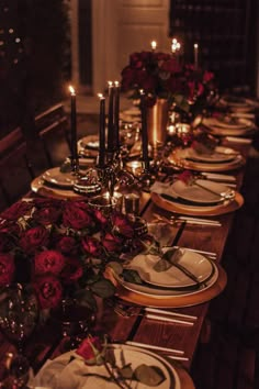 a long table is set with plates and candles for an elegant dinner or special event