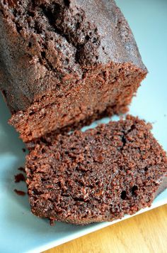 a loaf of chocolate cake sitting on top of a blue plate