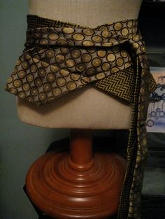 a mannequin with a brown and gold scarf on it's head