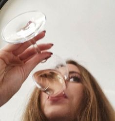 a woman holding a wine glass in front of her face