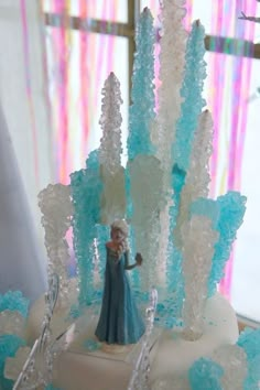 a frozen princess cake with blue frosting and icing on the top is displayed in front of a window