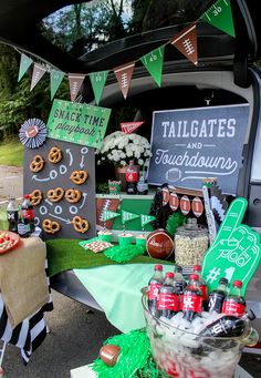 the tailgates and football themed dessert table is set up in the back of a car