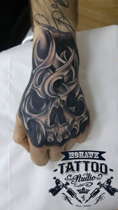 a man's hand with a tattoo on it and a skull in the middle