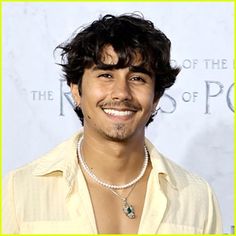 an image of a man smiling for the camera with pearls on his neck and chest