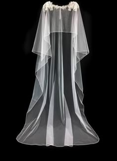 a white veil with flowers on it and a black back ground in the dark background