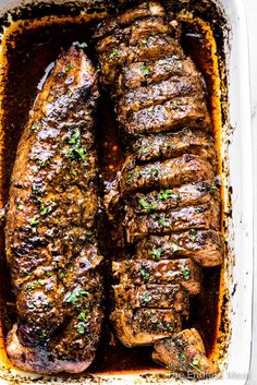 two steaks in a casserole dish with garnish