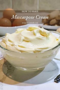 a glass bowl filled with mascarpone cream on top of a table next to eggs