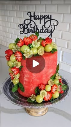 a watermelon birthday cake with grapes and strawberries