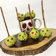 there are some cupcakes with green icing and red eyes on the sticks