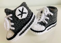 a pair of crocheted baby shoes sitting on top of a white countertop